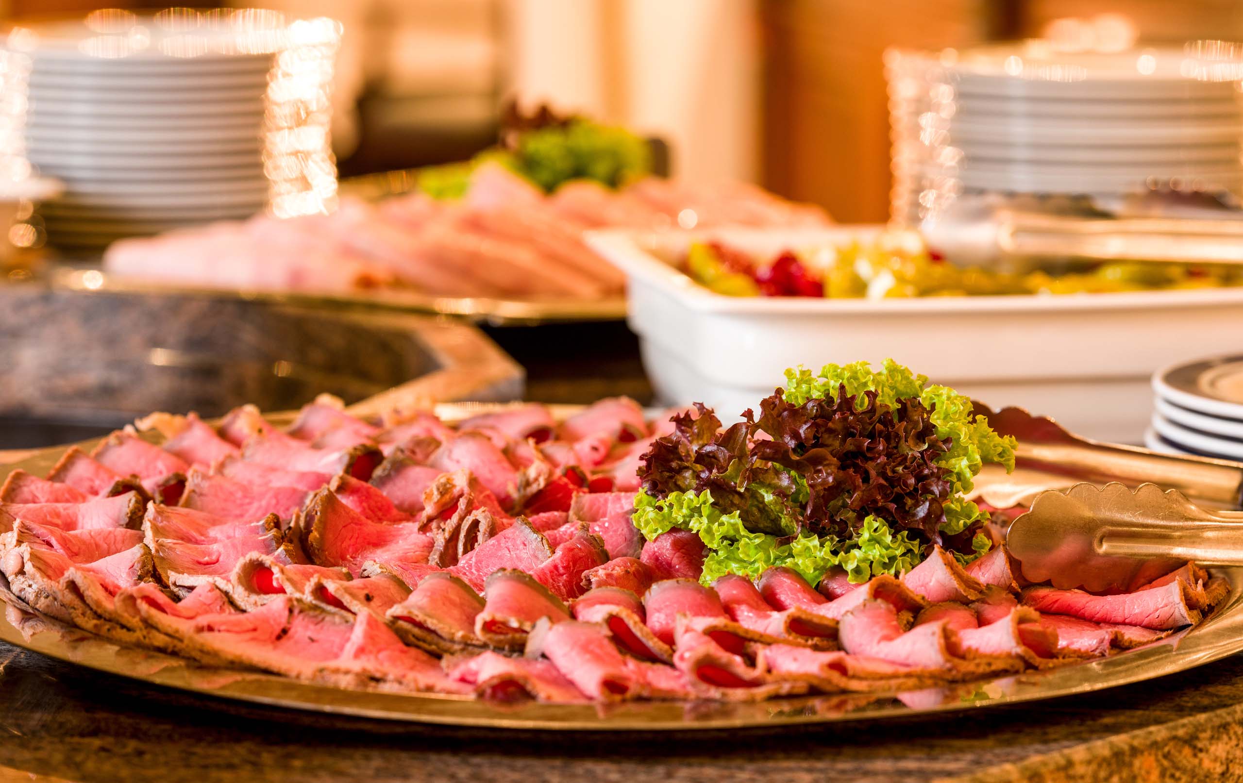 Saftiges Rindfleisch vom Buffet, leckerer Fleischaufschnitt mit frischem Salat, kalte Platten für Veranstaltungen, Food Catering in Österreich, Gourmetbuffet mit Schinken und Rindfleisch.